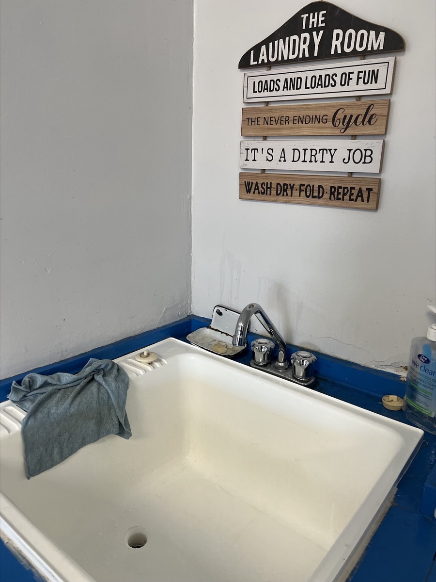 A laundry sink under a sign reading The Laundry Room, wash dry fold repeat